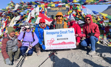 Trekkers walking toward Annapurna Base Camp surrounded by towering snow peaks.