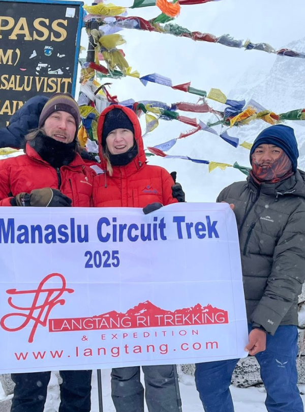 Trekkers walking along the rugged trails of the Manaslu Circuit with towering Himalayan peaks.