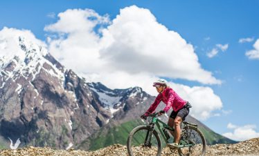 Annapurna Circuit Cycling Adventure -14 Day is posing with their bicycle at the top of Thorong La Pass (5,416m) during.