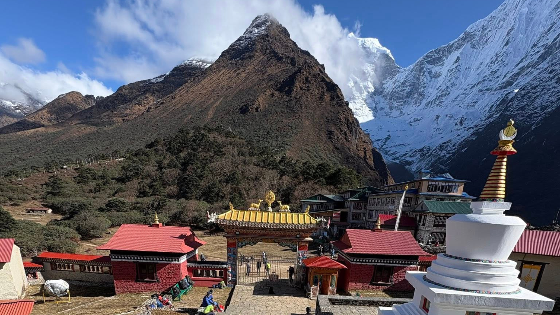 Monks performing sacred masked dances during the Mani Rimdu Festival at Tengboche Monastery with Himalayan mountains in the background.