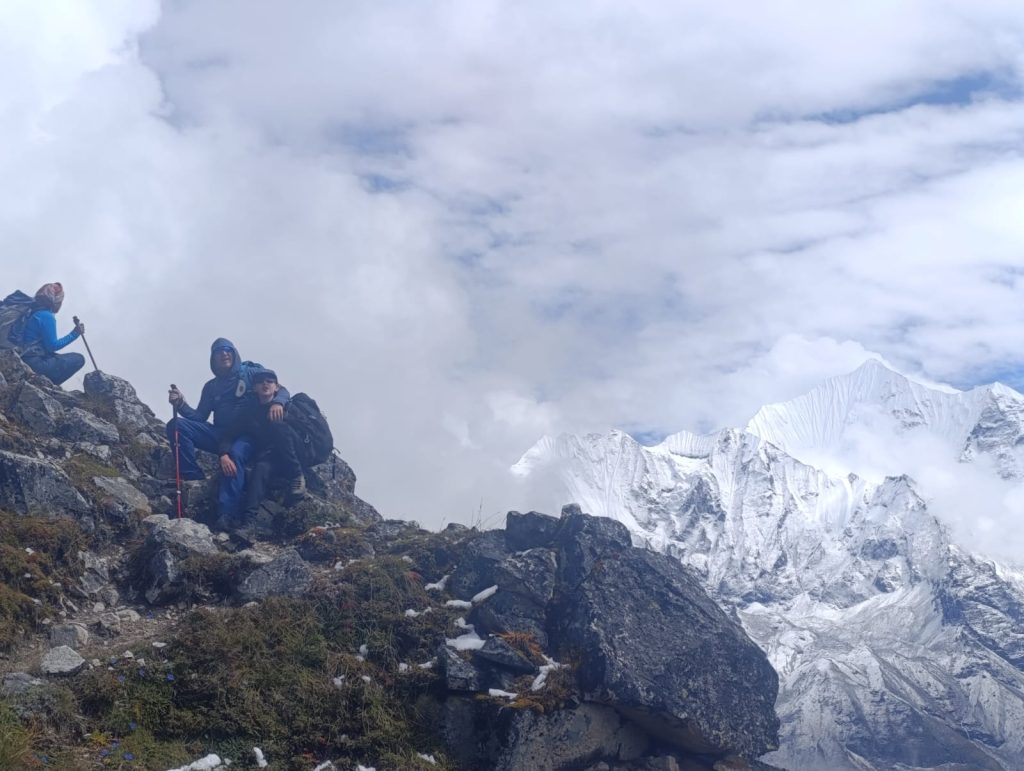 Helicopter landing near Rara Lake with turquoise water surrounded by forested hills in the Karnali region of Nepal.
