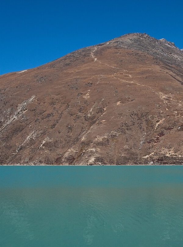 Helicopter flying over Gokyo Valley with turquoise lakes, glaciers, and Himalayan peaks in the Everest region of Nepal.