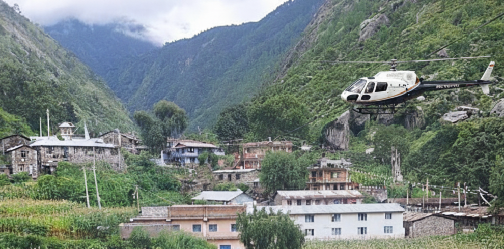 helicopter flying over Langtang Himalayan peaks with snow-capped mountains, green valleys, and a river below.