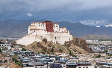 Pilgrims and travelers at sacred Lake Manasarovar with Mount Kailash rising in the background, via Kerung route.