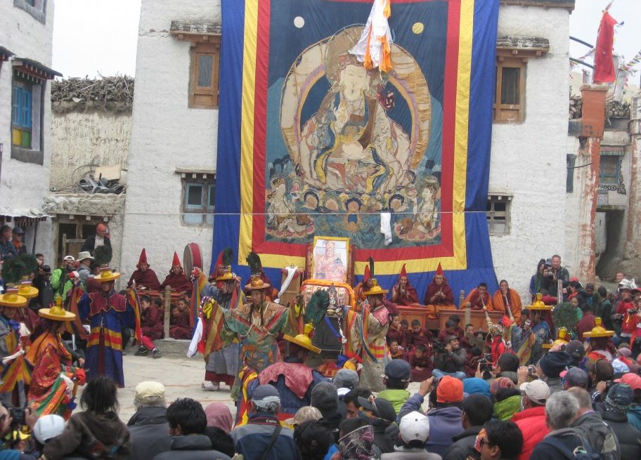 The snow-capped peak of Mount Kailash in Tibet under a clear blue sky, surrounded by colorful prayer flags during the Saga Dawa festival.