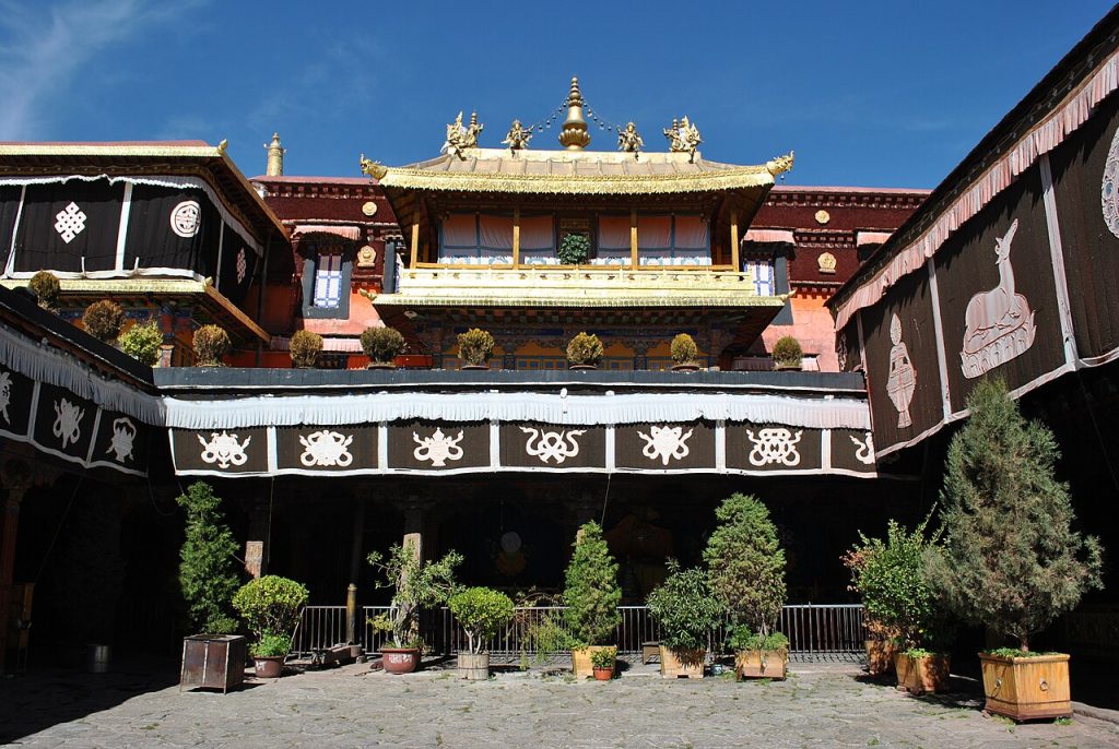 Sacred Charm of Jokhang Temple 2026 with golden rooftop, Tibetan architecture, and colorful prayer flags in Lhasa