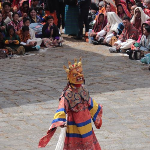 Vibrant masked dance performance at a Bhutanese festival.