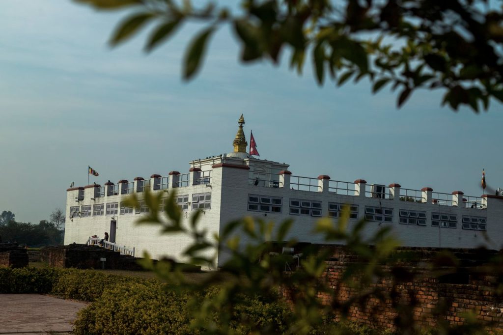 View of the Maya Devi Temple, a UNESCO heritage site in Lumbini, Nepal, under clear blue sky.