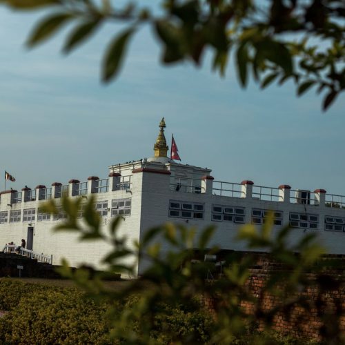 View of the Maya Devi Temple, a UNESCO heritage site in Lumbini, Nepal, under clear blue sky.